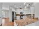 Bright kitchen with stainless appliances, granite counters, pendant lights, and open to the living room at 5548 Woodwind Hills Dr, Lakeland, FL 33812