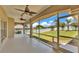 Relaxing screened-in porch with ceiling fans, offering beautiful views of the lush backyard and blue sky at 5548 Woodwind Hills Dr, Lakeland, FL 33812
