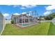 This home features a large, manicured backyard with a privacy fence, in-ground swimming pool, and screened outdoor patio at 5579 Summerland Hills Dr, Lakeland, FL 33812