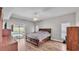 Spacious bedroom with wood floors, ceiling fan, slider doors to pool, and natural light at 5579 Summerland Hills Dr, Lakeland, FL 33812