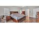 Bedroom with wood floors, a large bed, dual dressers, and natural light from the windows at 5579 Summerland Hills Dr, Lakeland, FL 33812