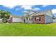 Side view of the home showing the manicured lawn, brick accents, and inviting front porch at 5579 Summerland Hills Dr, Lakeland, FL 33812
