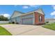 The side of the house featuring a spacious driveway leading to an attached two-car garage at 5579 Summerland Hills Dr, Lakeland, FL 33812
