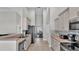 Galley-style kitchen features tile backsplash, stainless steel appliances, and tile flooring, leading to a dining area at 5579 Summerland Hills Dr, Lakeland, FL 33812