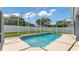 This in-ground swimming pool is surrounded by a screened enclosure and has clean, well-manicured landscaping and a privacy fence at 5579 Summerland Hills Dr, Lakeland, FL 33812