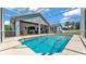 Aerial view of the beautiful in-ground pool and screened patio surrounded by well-manicured landscaping and privacy fence at 5579 Summerland Hills Dr, Lakeland, FL 33812