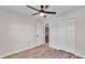 Comfortable bedroom with wood-look flooring, ceiling fan, closet, and neutral walls at 577 Majestic Gardens Blvd, Winter Haven, FL 33880