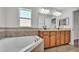 Elegant bathroom featuring dual sinks, soaking tub, and tiled accents for a luxurious experience at 577 Majestic Gardens Blvd, Winter Haven, FL 33880