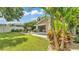 Lush backyard showcasing a pool, outdoor seating, mature trees, and vibrant landscaping at 608 Finney St, Lakeland, FL 33803