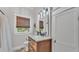 Bathroom featuring a wooden vanity with marble countertop and stylish fixtures, complemented by a window and neutral decor at 608 Finney St, Lakeland, FL 33803