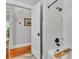 Well-lit bathroom with a shower-tub combo, white tile, and black hardware at 608 Finney St, Lakeland, FL 33803