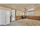 Living room with wood paneling, carpeting, and access to the kitchen at 640 Forrest Dr, Bartow, FL 33830