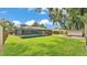 Expansive backyard features a screened-in pool, lush lawn, and additional storage shed at 6406 Butternut Dr, Lakeland, FL 33813