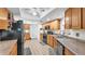 Well-lit kitchen with oak cabinets, tiled floor, and black appliances, providing ample storage and modern conveniences at 6406 Butternut Dr, Lakeland, FL 33813