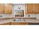 This kitchen features wood cabinets, granite counters, and a pass through to the living room at 6406 Butternut Dr, Lakeland, FL 33813