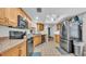 Updated kitchen features stainless steel appliances, tiled flooring, and wood cabinets for efficient meal preparation at 6406 Butternut Dr, Lakeland, FL 33813