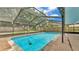 Large screened-in pool with surrounding brick patio and lush landscaping at 6406 Butternut Dr, Lakeland, FL 33813