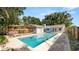 View of a sparkling pool, patio, seating, and wood fence at 6421 Calusa Dr, Lakeland, FL 33813