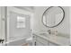 Bright bathroom with white fixtures, a mirror, and a tub at 6707 Hillis Dr, Lakeland, FL 33813