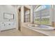 Bright bathroom with arched window, glass shower, and a soaking tub at 6707 Hillis Dr, Lakeland, FL 33813
