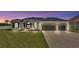 Beautiful home at dusk with a well-manicured lawn, three-car garage, and stylish black and white exterior at 6707 Hillis Dr, Lakeland, FL 33813