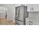 A stainless steel refrigerator against white cabinets with quartz countertops in a modern kitchen at 6707 Hillis Dr, Lakeland, FL 33813