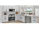 Modern white kitchen with stainless steel appliances and granite countertops at 6707 Hillis Dr, Lakeland, FL 33813