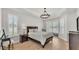 Bright main bedroom with light wood floors, tray ceilings, and a modern chandelier at 6707 Hillis Dr, Lakeland, FL 33813