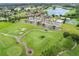 A scenic aerial view features a golf course, lakes, residential area, clubhouse, pool, and tennis courts in a vibrant community at 6964 Lake Eaglebrooke Dr, Lakeland, FL 33813