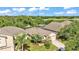Aerial view of a home with mature landscaping, a well-manicured lawn, and a view of a lake in the distance at 6964 Lake Eaglebrooke Dr, Lakeland, FL 33813