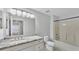Bathroom with marble countertop vanity, bright lights, and a shower-tub combo at 6964 Lake Eaglebrooke Dr, Lakeland, FL 33813
