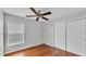 Bedroom featuring hardwood floors, a window with blinds, neutral walls, and a closet at 6964 Lake Eaglebrooke Dr, Lakeland, FL 33813