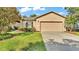 Inviting home exterior with a two-car garage, complemented by a green lawn and garden beds at 6964 Lake Eaglebrooke Dr, Lakeland, FL 33813