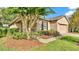 Charming home exterior featuring a well-manicured lawn and lush landscaping, with a tan exterior at 6964 Lake Eaglebrooke Dr, Lakeland, FL 33813