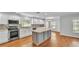 Modern kitchen with white cabinetry, granite countertops, stainless steel appliances, and a central island at 6964 Lake Eaglebrooke Dr, Lakeland, FL 33813