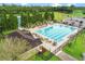 The pool area, surrounded by lush greenery and lounge chairs, includes a nearby tennis court, offering various recreational activities at 6964 Lake Eaglebrooke Dr, Lakeland, FL 33813