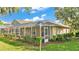 Covered, screened in back porch with a view of the landscaped backyard and manicured shrubs at 6964 Lake Eaglebrooke Dr, Lakeland, FL 33813