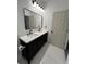 Bathroom with black double vanity, white countertops, large mirror, and modern fixtures at 801 Robson W St, Lakeland, FL 33805
