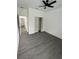 This bedroom features gray wood flooring, white walls, a ceiling fan, and closet for ample storage at 801 Robson W St, Lakeland, FL 33805
