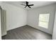 This bedroom features a modern ceiling fan, gray wood flooring, and natural light from the window at 801 Robson W St, Lakeland, FL 33805