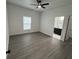 Bright bedroom with ceiling fan, wood-look floors, white walls, and view of bathroom at 801 Robson W St, Lakeland, FL 33805