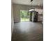A modern dining area featuring a stylish chandelier, stainless steel refrigerator, and sleek sliding glass doors at 801 Robson W St, Lakeland, FL 33805