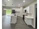 Open concept kitchen features a modern island with sink, stainless appliances, and white cabinetry at 801 Robson W St, Lakeland, FL 33805