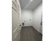 A compact laundry room with gray wood-look flooring, white walls and basic utility hookups at 801 Robson W St, Lakeland, FL 33805