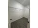 Bright walk-in closet featuring white walls, wire shelving, wood-look flooring, and door at 801 Robson W St, Lakeland, FL 33805