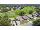 Aerial view showcasing a home nestled in a neighborhood with green spaces, trees, and a nearby pond at 849 Rockingham Rd, Lakeland, FL 33809