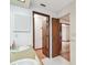 Bright bathroom featuring double sinks, white cabinets, and a doorway to the bedroom at 849 Rockingham Rd, Lakeland, FL 33809