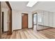 Bright living room featuring wood floors, skylight and mirrored closet doors at 849 Rockingham Rd, Lakeland, FL 33809