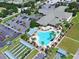Aerial view of a community pool, clubhouse, parking area, and landscaped grounds at 9017 Se 119Th St, Summerfield, FL 34491