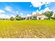 A beautiful lawn with palm trees leading up to a beige house with a screened lanai at 9017 Se 119Th St, Summerfield, FL 34491